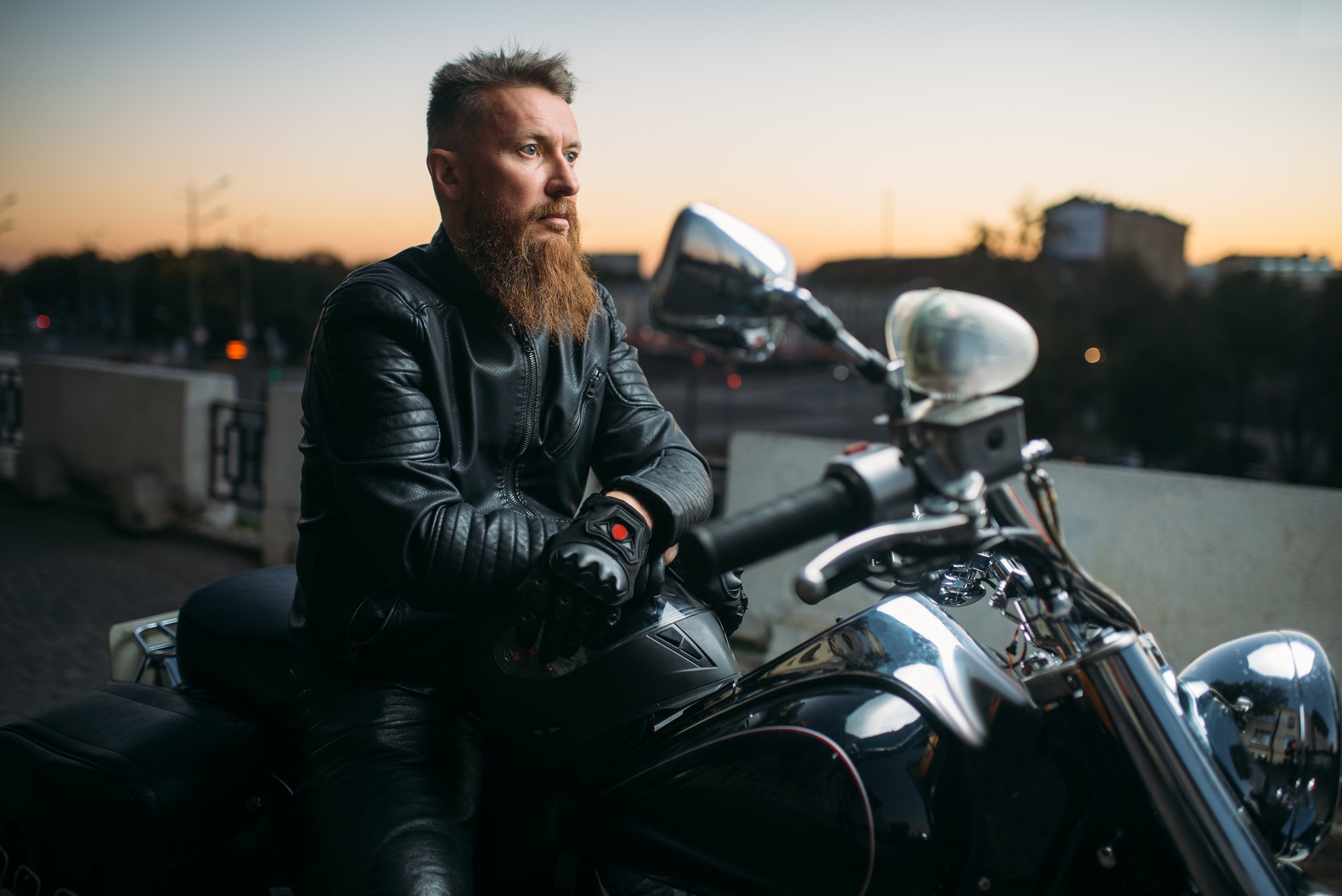 biker-poses-on-a-motorcycle-in-city-on-sunset.jpg